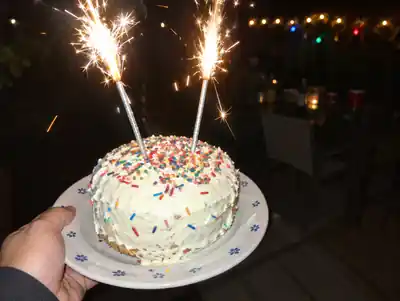 A birthday cake with two sparklers